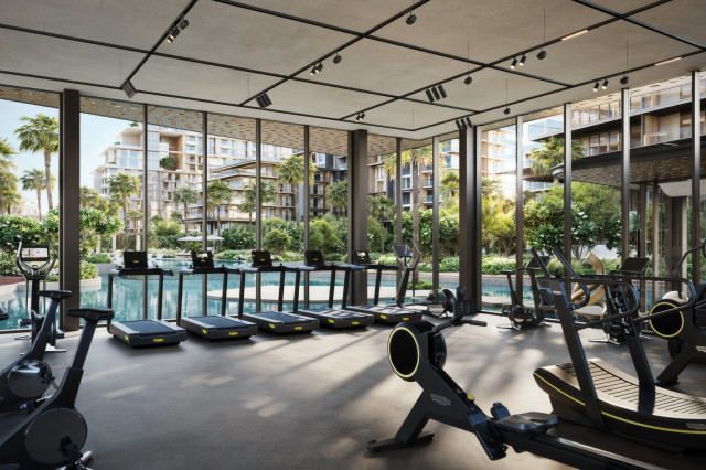 Salle de sport haut de gamme avec équipements modernes et grandes baies vitrées donnant sur la piscine